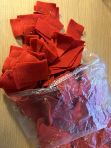 a pastic bag filled with squared pieces of red cloth